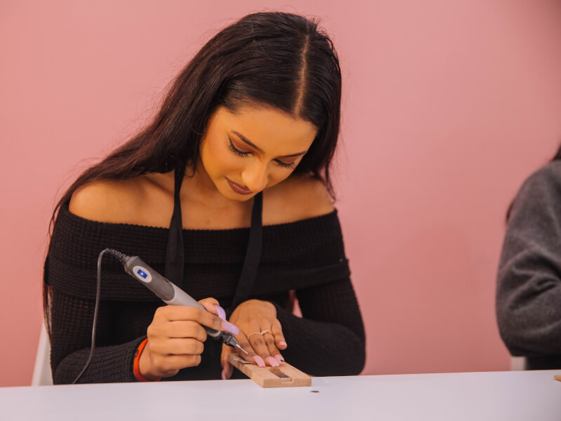 A woman making her own ring at a ring making workshop. 